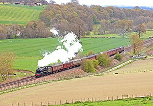 ex-LMS 'Royal Scot’, Class 4-6-0, 46100 is approaching Craven Arms close to Stokesay Castle.